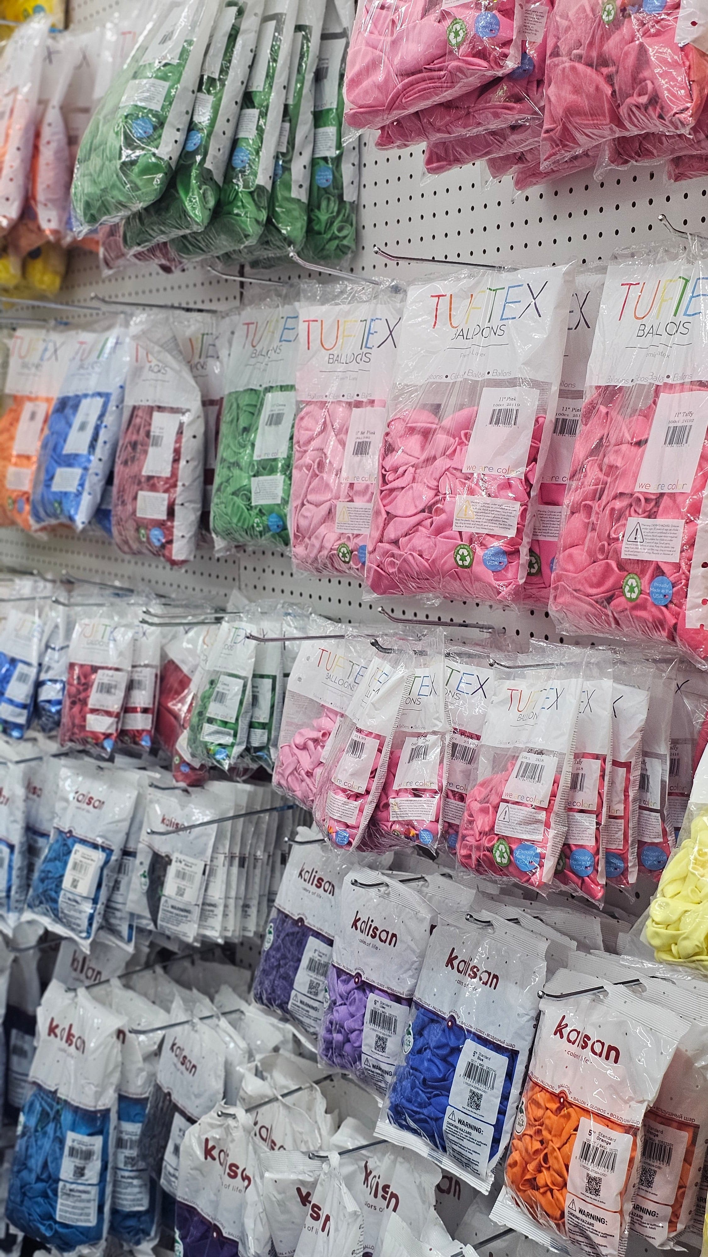 A wall of Tuftex balloons packaged in different color options.